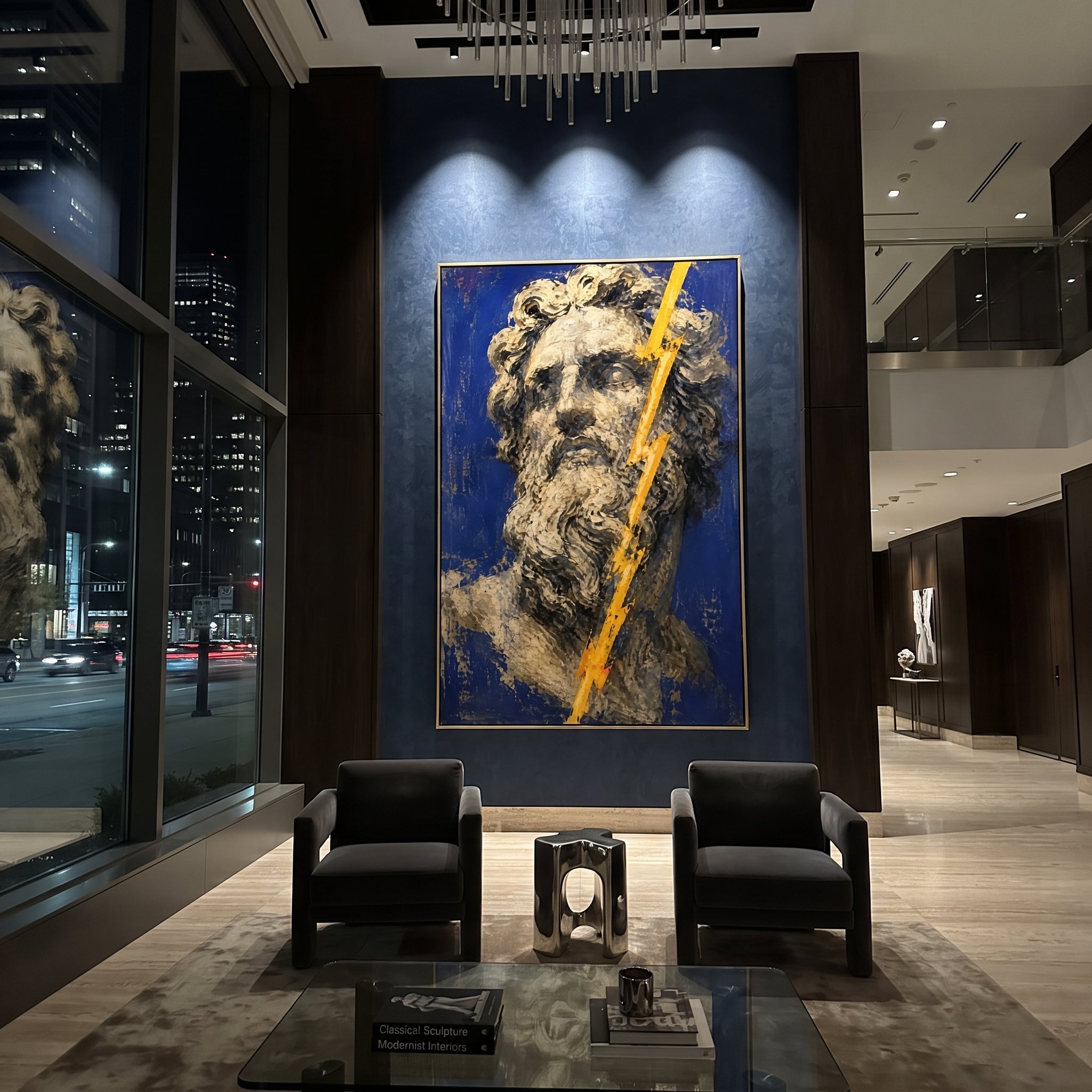 Zeus stares out from a field of blue as lightning cuts across his face. The image carries command without motion, as if divine anger has become stone and light.