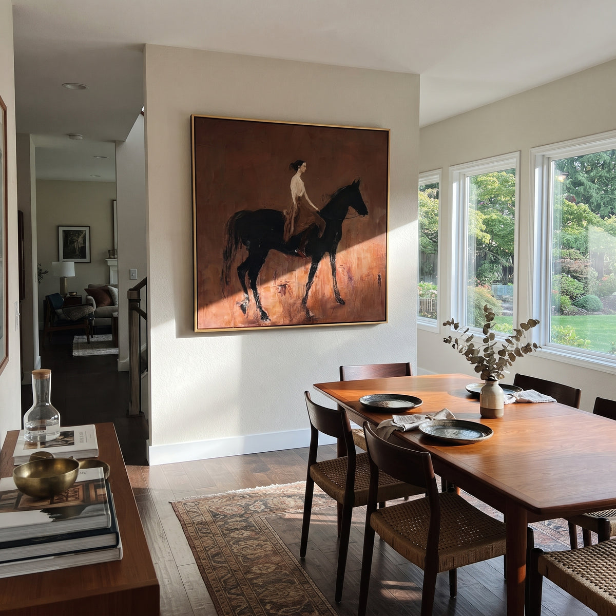 Rider Across Sienna - black horse and rider painting displayed in a styled interior